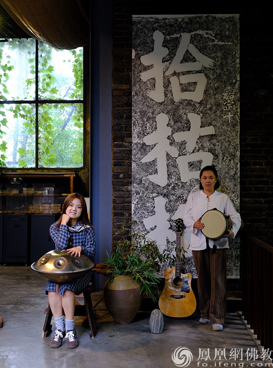两名音乐老师在巨幅作品下准备活动
