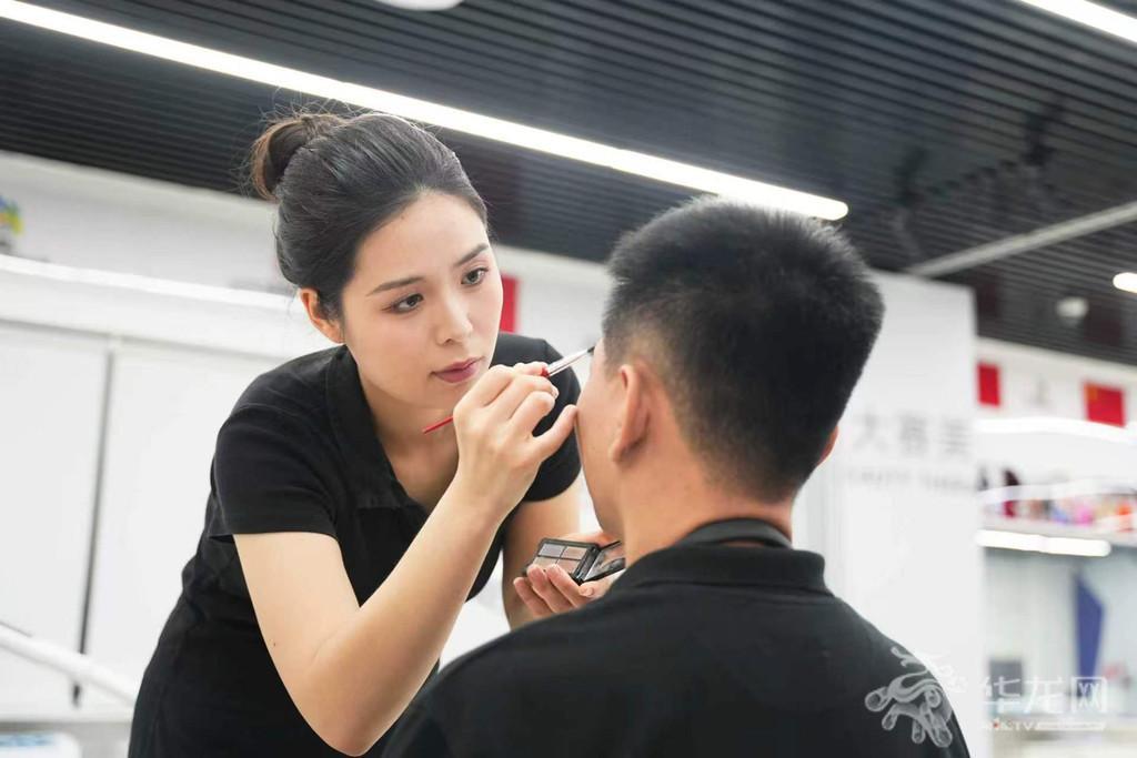 姚苗苗给体验嘉宾化妆。第1眼TV-华龙网记者 辛飞 摄