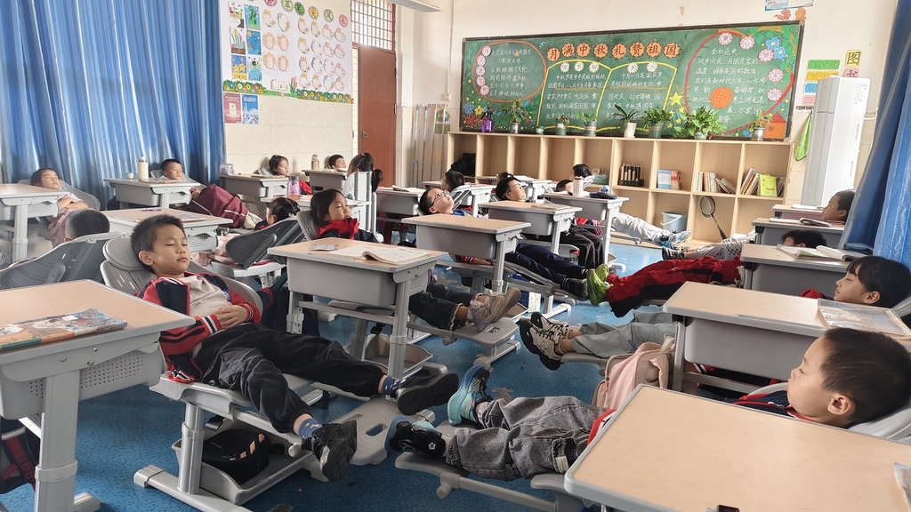 荣昌区龙集镇中心小学,学生们在可躺式课桌椅上午休。受访者供图