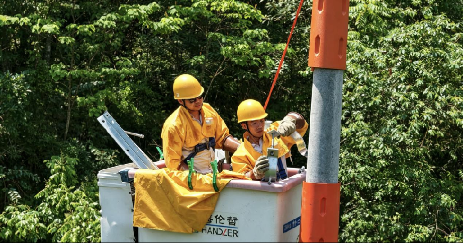 国网重庆武隆供电公司员工在仙女山镇带电组立电杆。受访单位供图