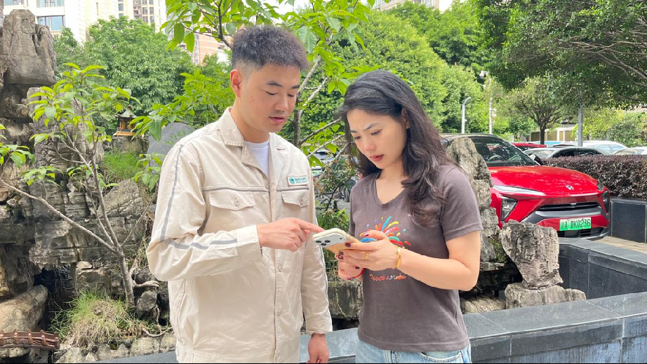 国网重庆营销服务中心员工给客户介绍安装个人充电桩办理流程。受访单位供图