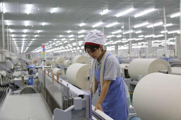 图木舒克市冠图纺织企业 技术工人正在检查布匹生产情况 崔显朝摄